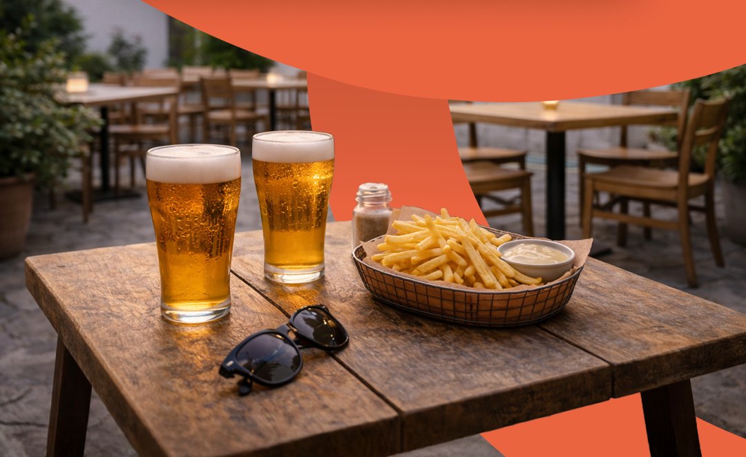 Mesa de bar com cervejas e porção de fritas